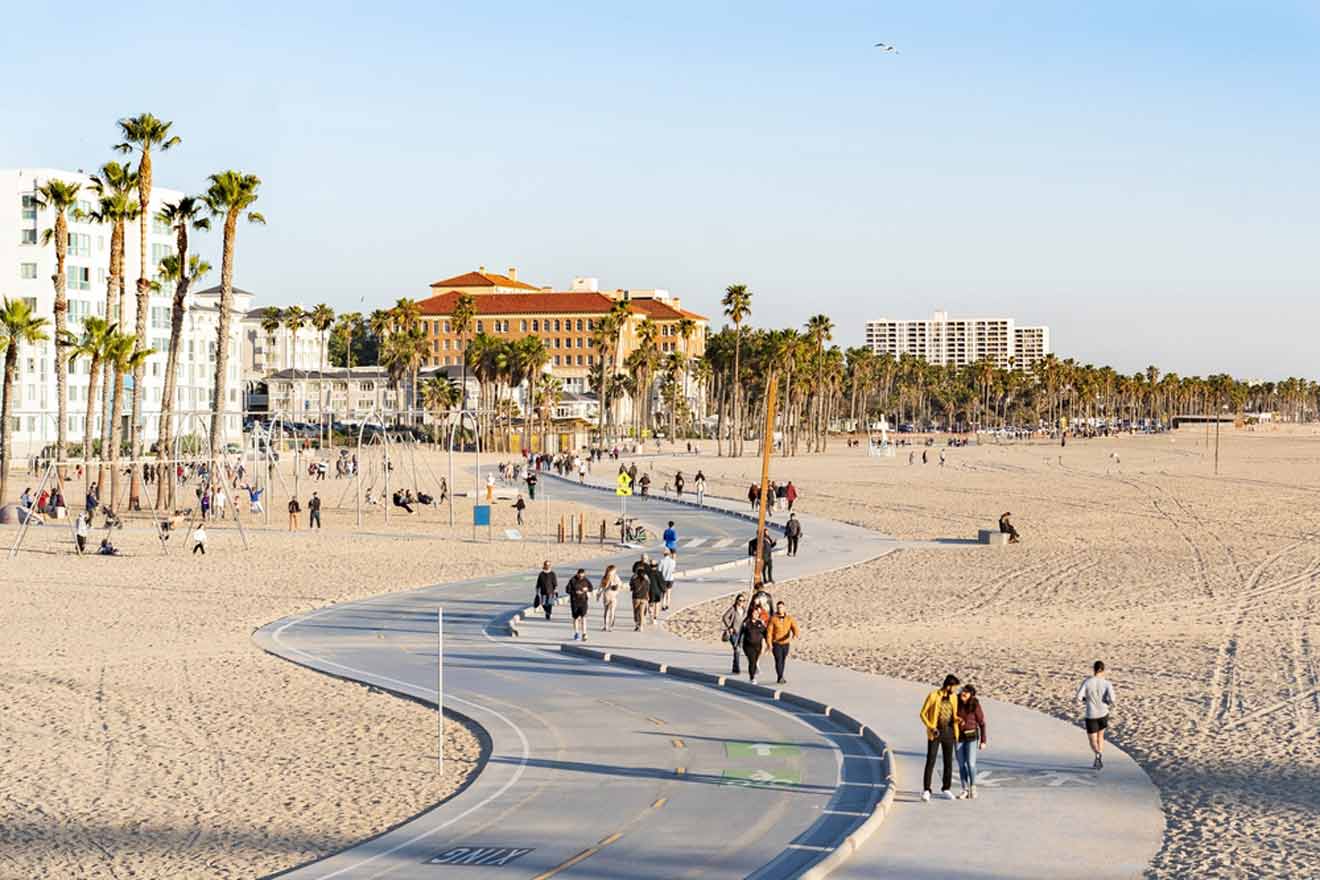 a group of people walking along a beach next to palm trees