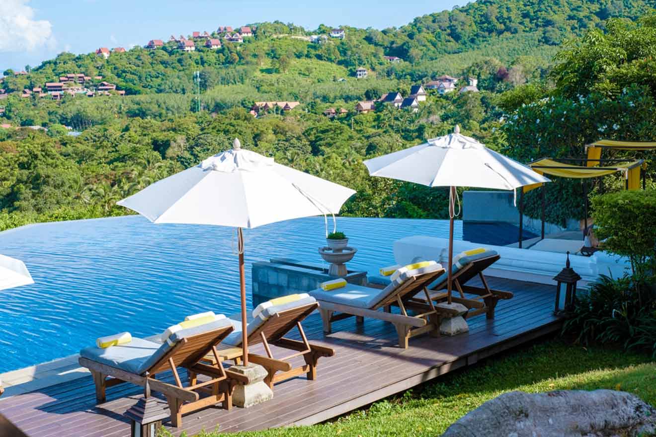 a couple of lawn chairs sitting on top of a wooden deck near the pool