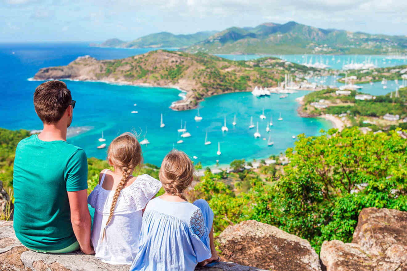 a man and two children sitting on a rock overlooking a bay