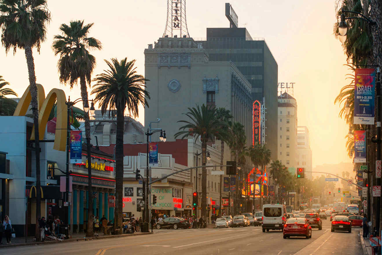 a city street filled with traffic next to tall buildings at sunset