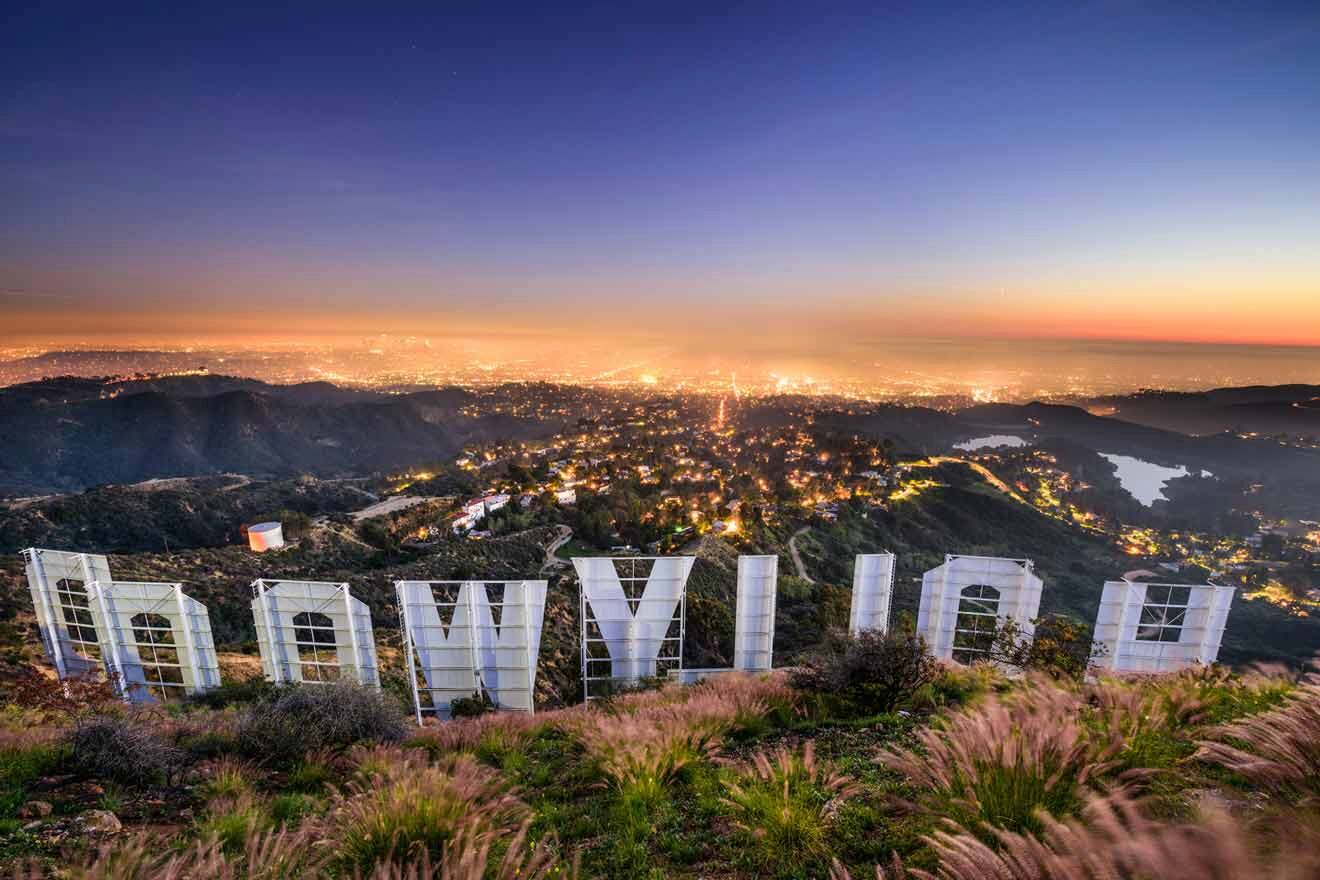 Hollywood sign view from behind overlooking the city and lake at night