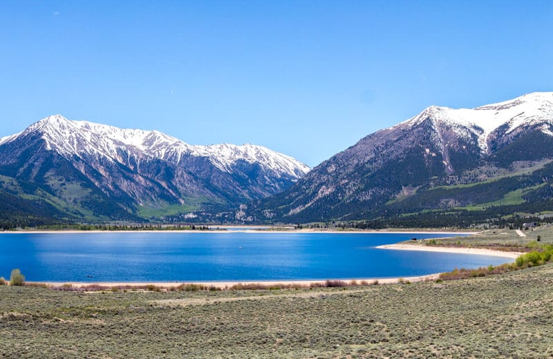 clear lake with mountains in background 