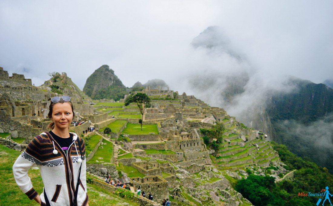 A girl posing in front of ruins of Ollantaytambo 