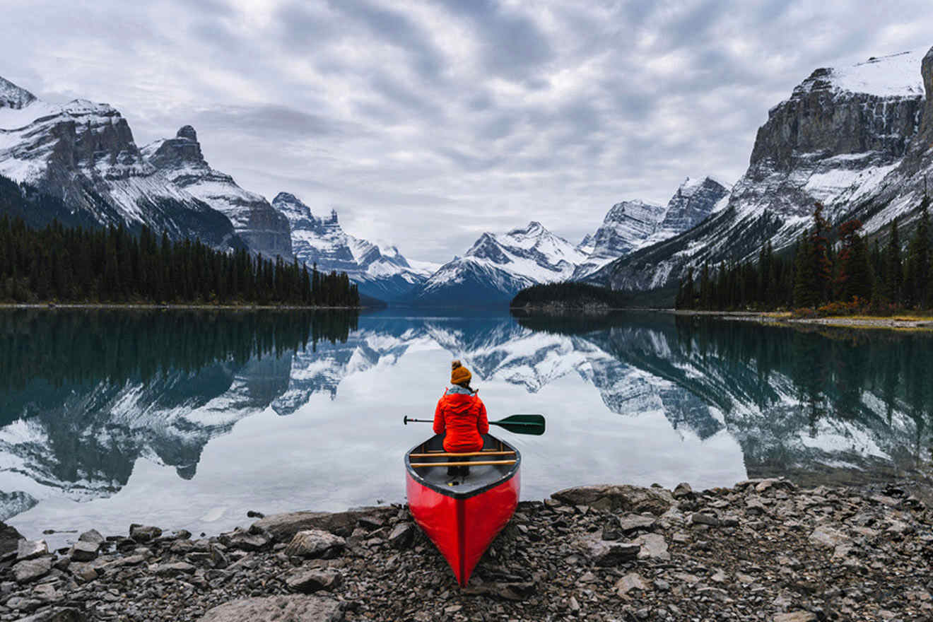 a person in a red kayak on a rocky shore