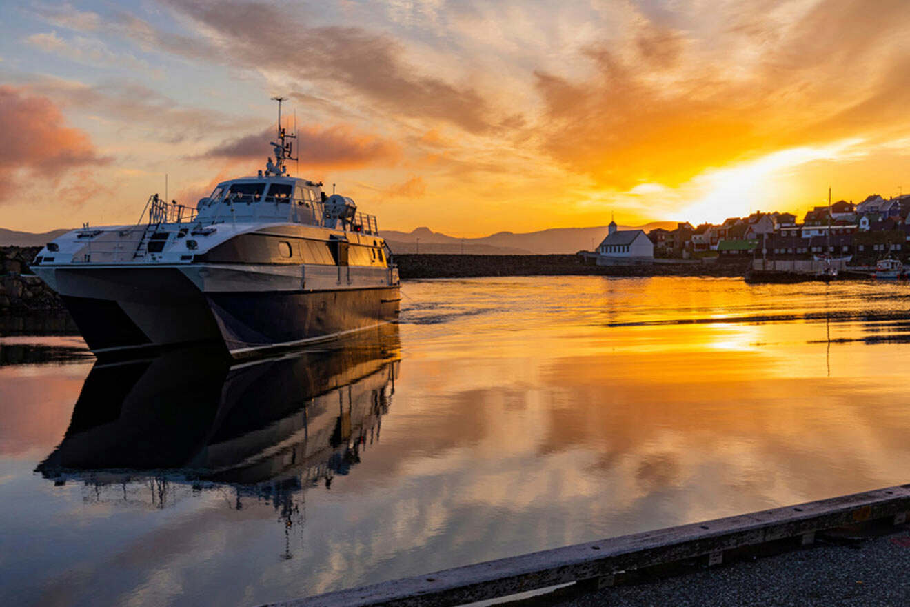 a large boat floating on top of water at sunset