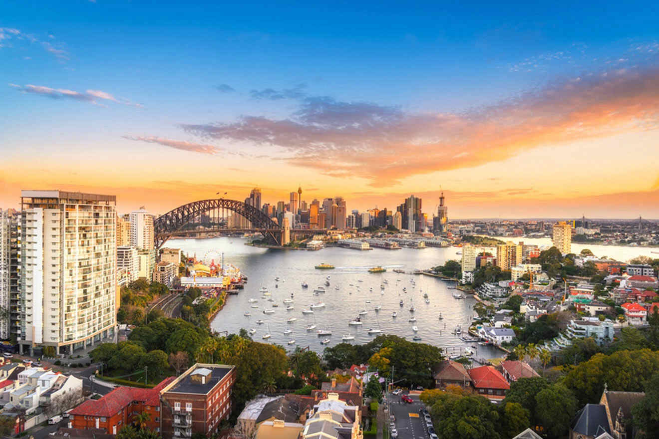 a beautiful sunset over a city with boats in the harbor