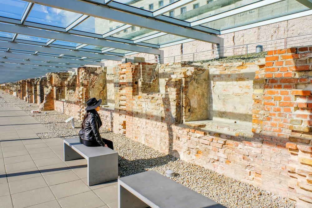 person looking at crumbling brick wall at Topography of Terror Museum