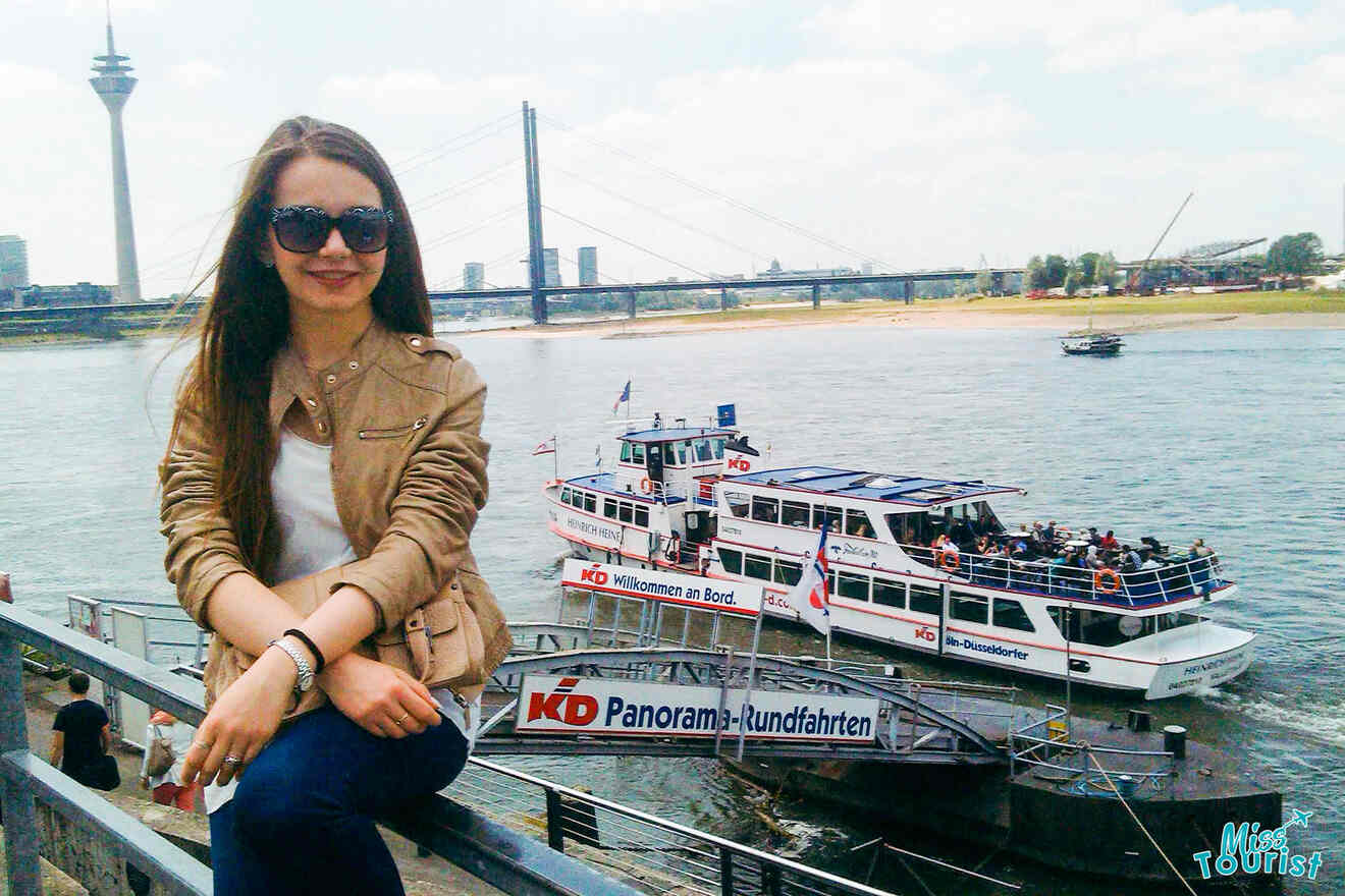 a girl sat next to the water next to a boat