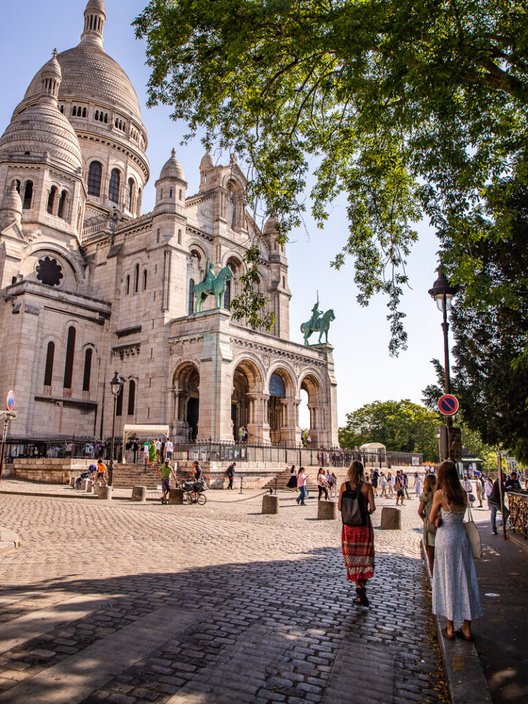 people walking under tree framing basilica sacre coeur