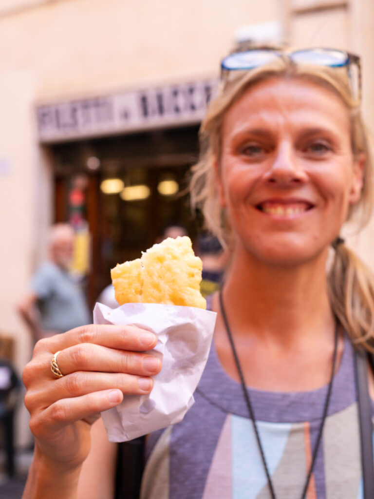 person holding piece of fried fish