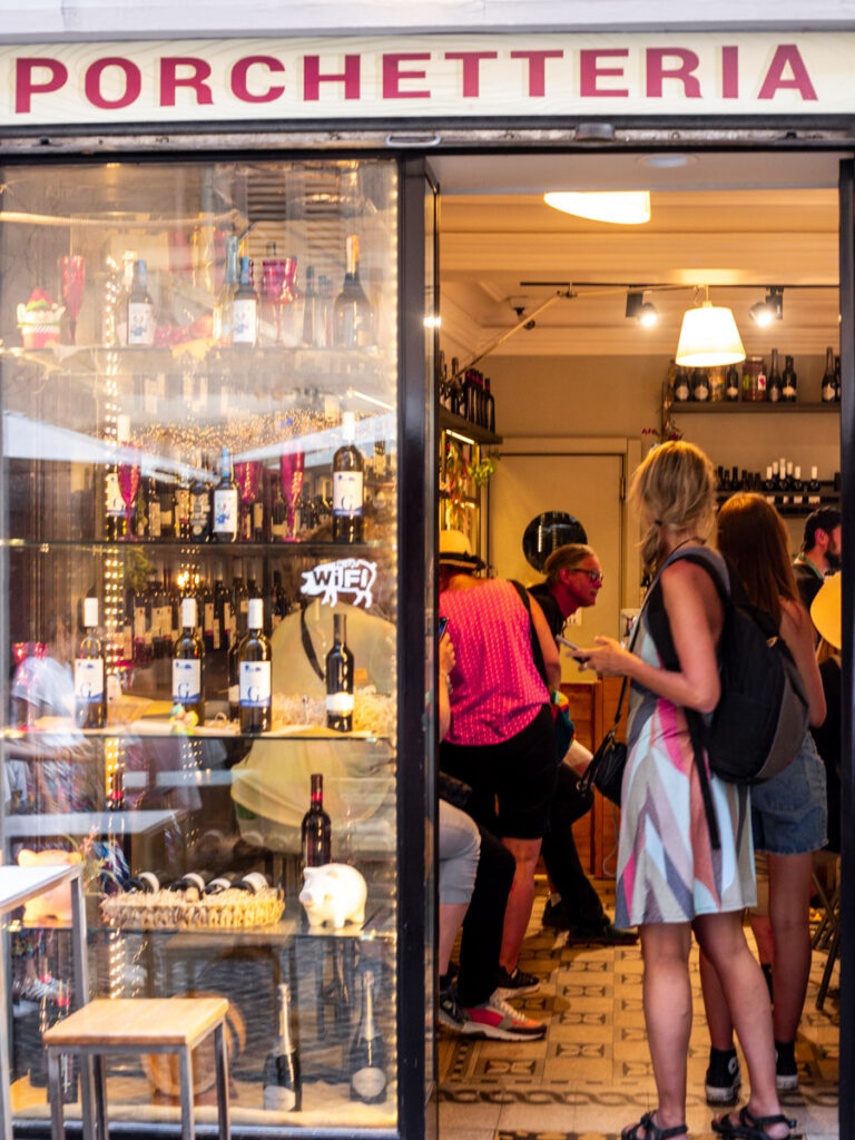 people walking in doorway of porchetteria