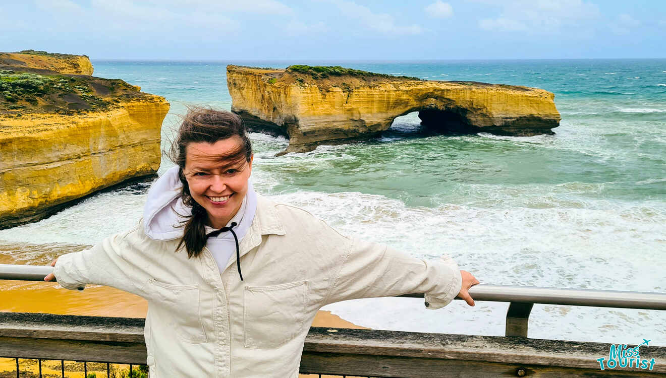 a person holding the railing overlooking a cliffs