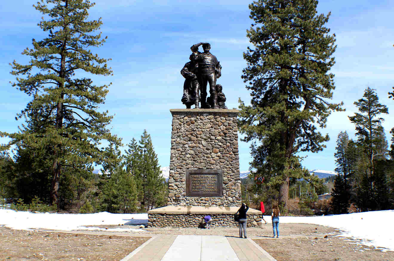 people walking around and taking photos of a monument with a family