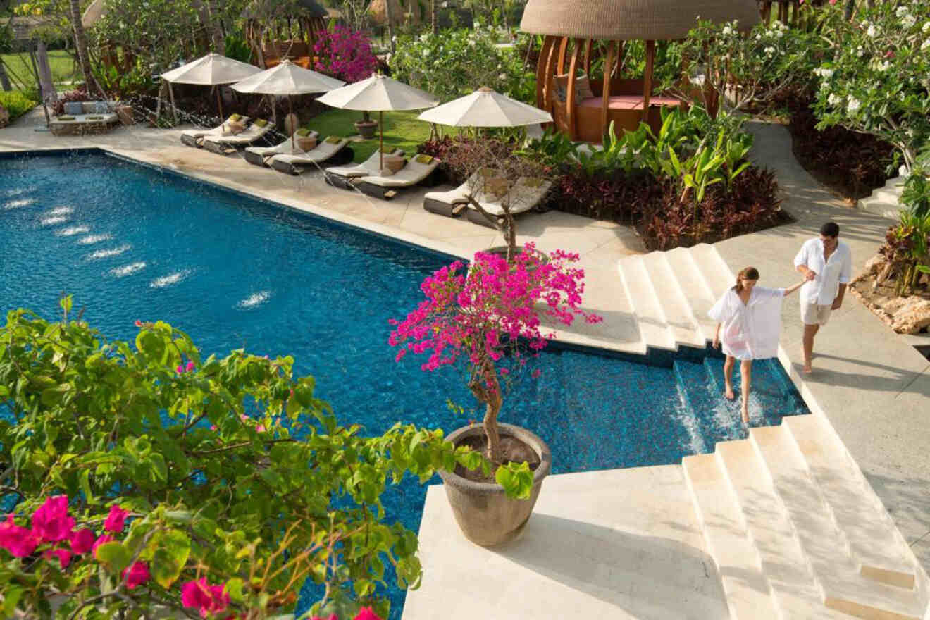 A couple walking by a pool at a resort in bali.