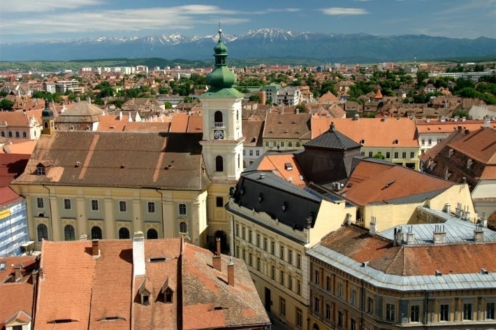 A view of a city with snow capped mountains in background