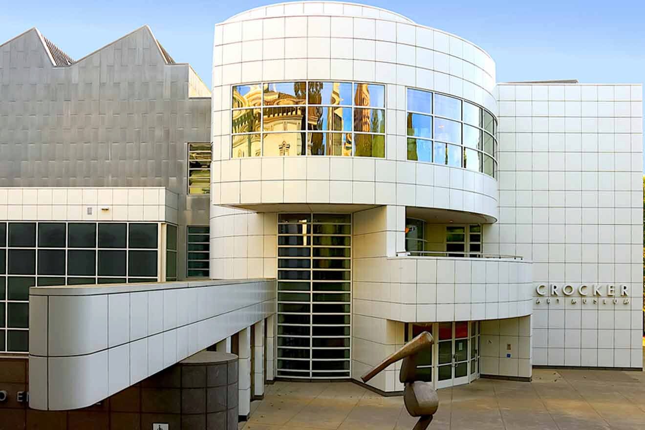 A white building with a sculpture in front of it.