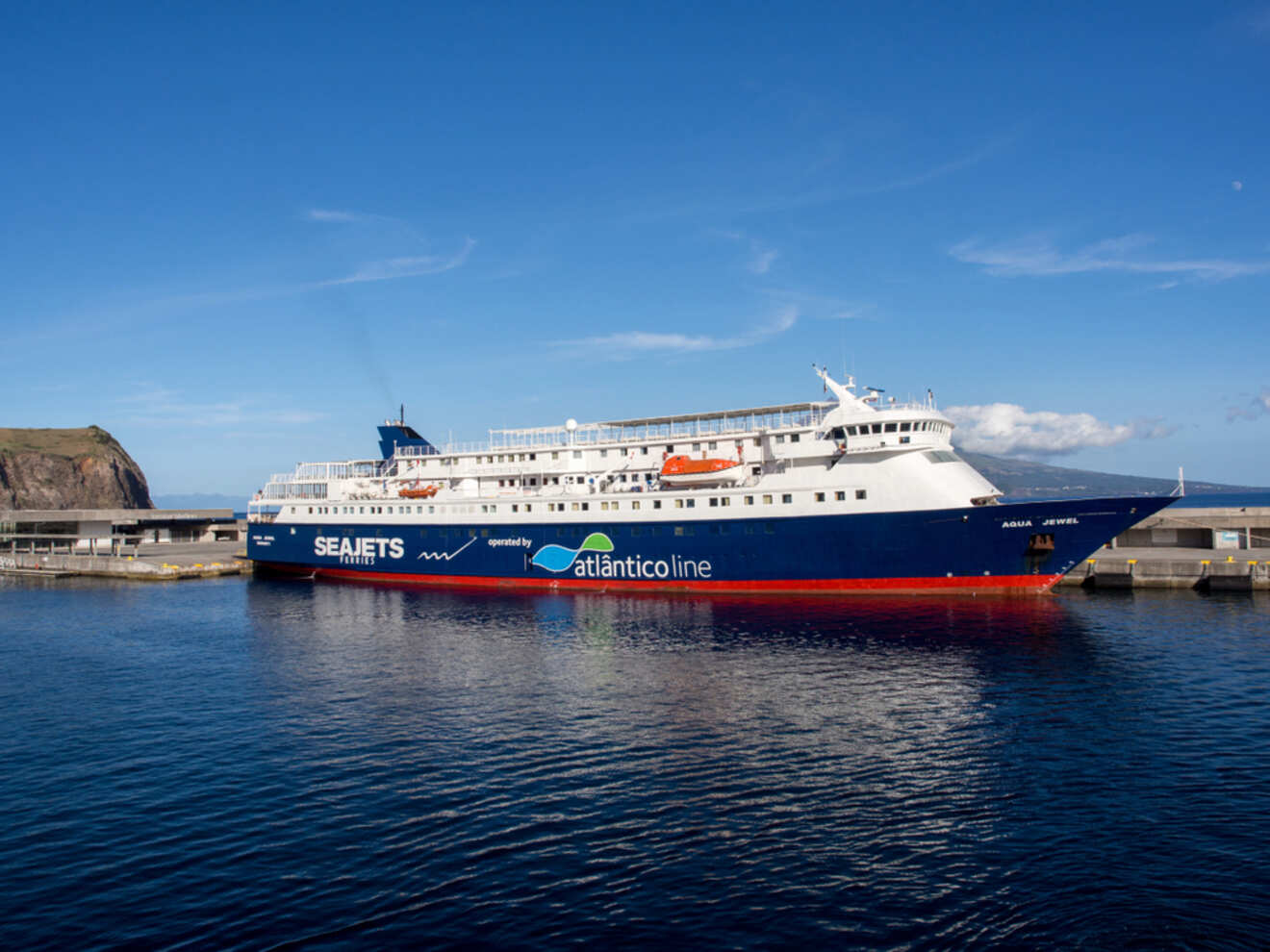 A large white and blue ferry docked at a dock.