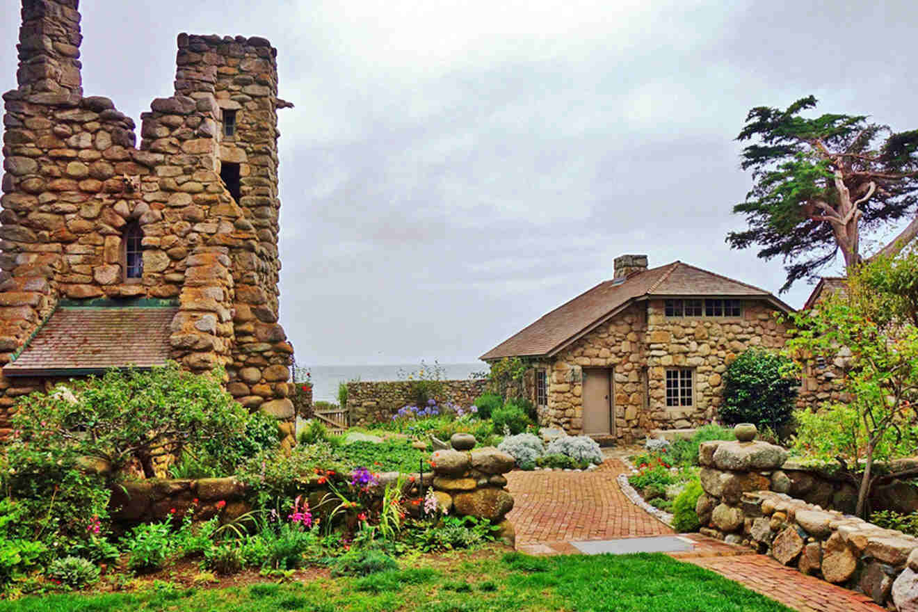 A stone house in a garden near the ocean.