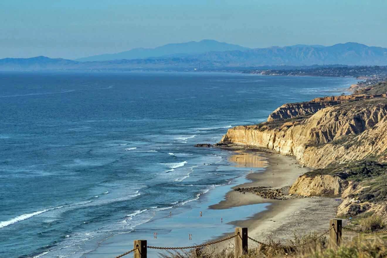 A cliff overlooking a beach and ocean.