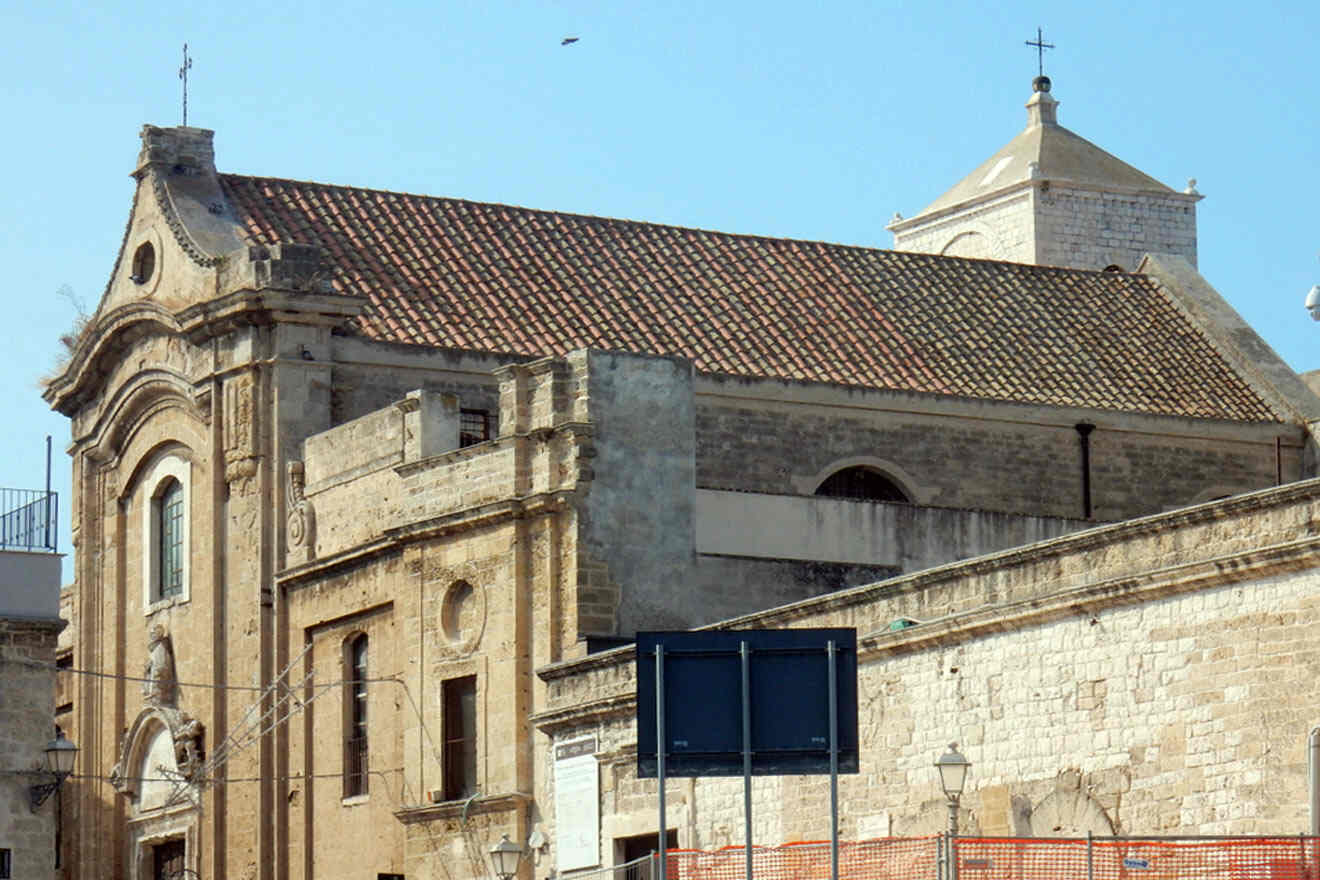 A brick building with a red roof and crosses on top of it