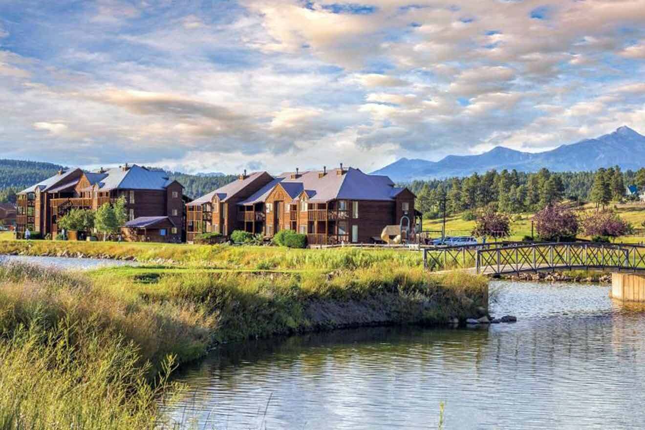 A resort with a river and mountains in the background.