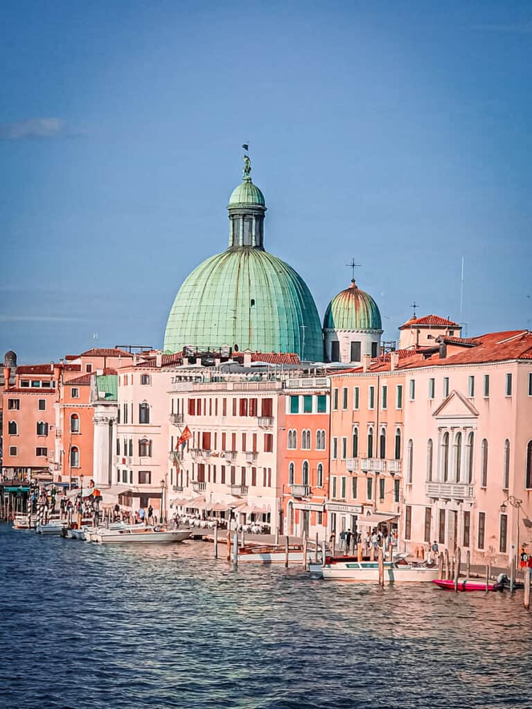 colorful buildings and dome along side canal