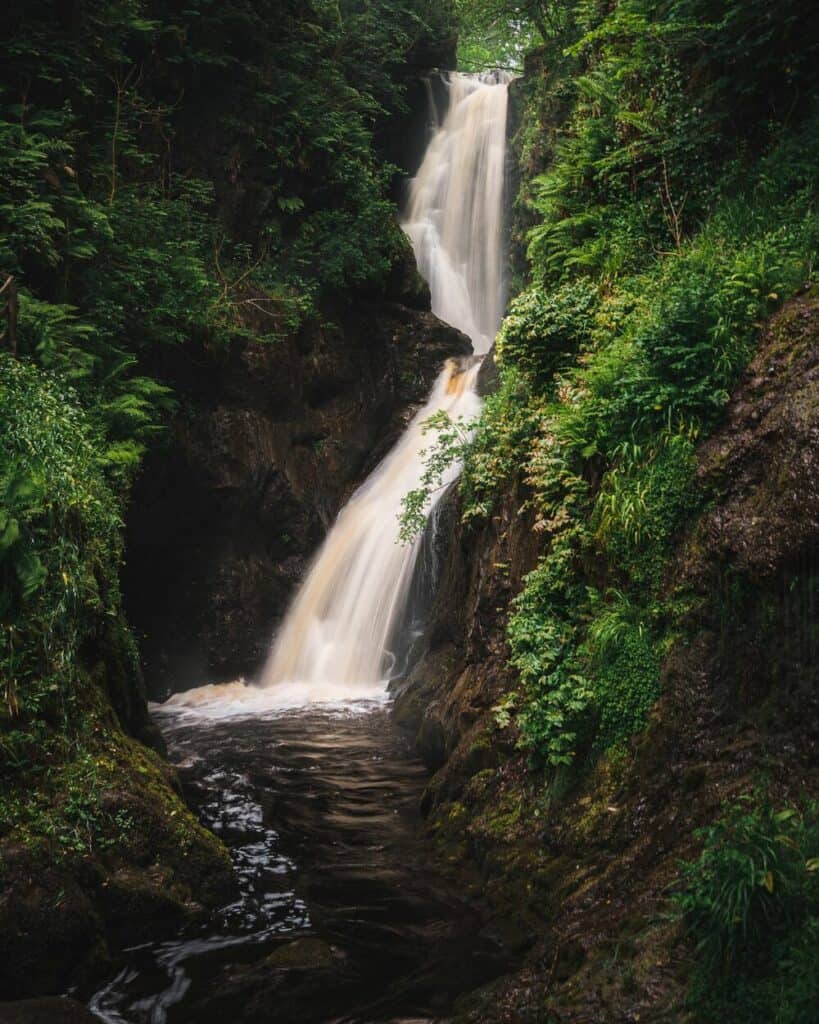 waterfall gushing down cliff Glenariff Forest Park