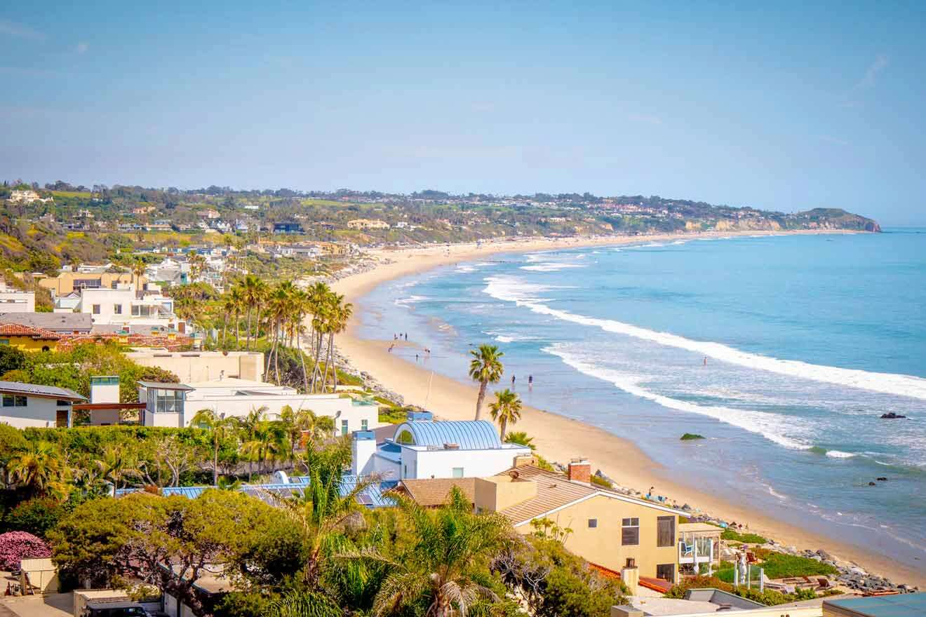 aerial view over the beach with lots of buildings and trees