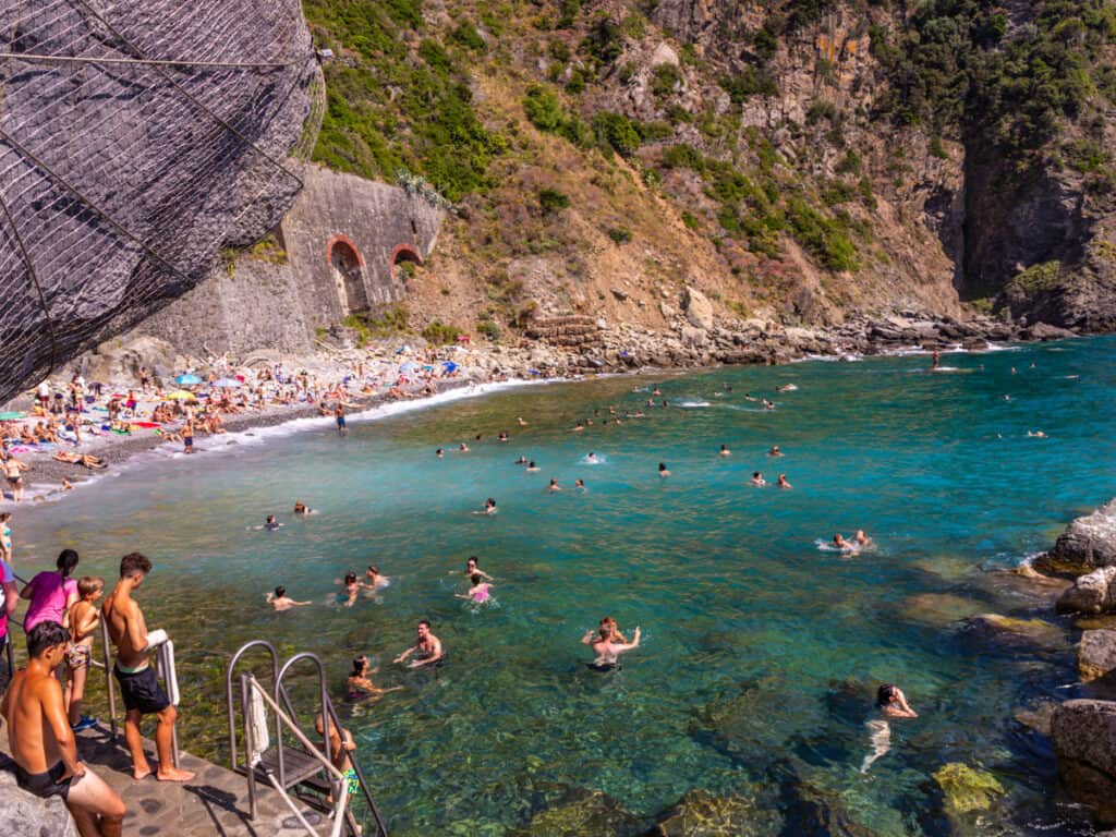 rocky beach with peop;el swimming in the water