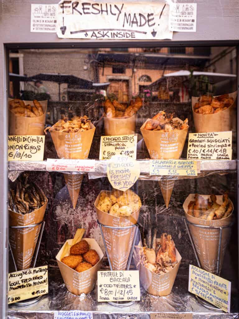 row of fried seafood in cones in shop display