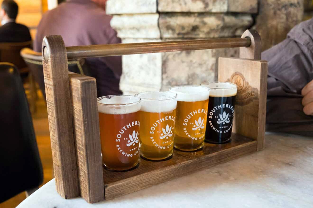 a row of beer glasses sitting on top of a wooden tray