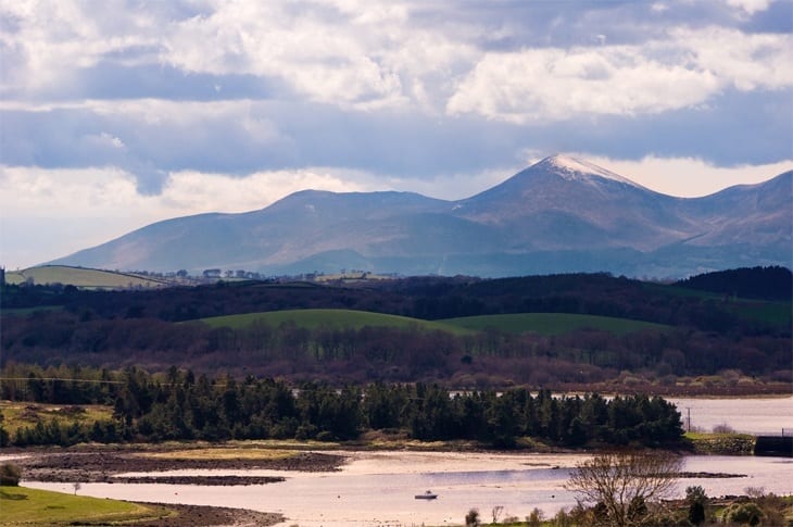 A body of water with a mountain in the background