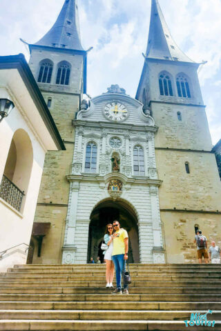 A man and woman standing in front of a church.