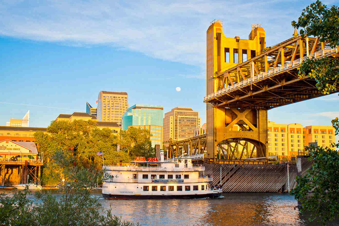 A boat sails under a bridge.