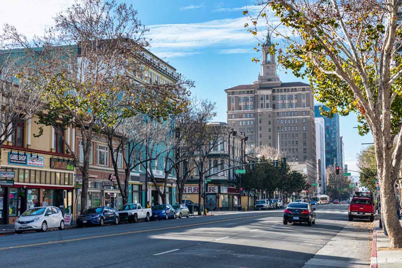 A street with tall buildings, cars and trees.