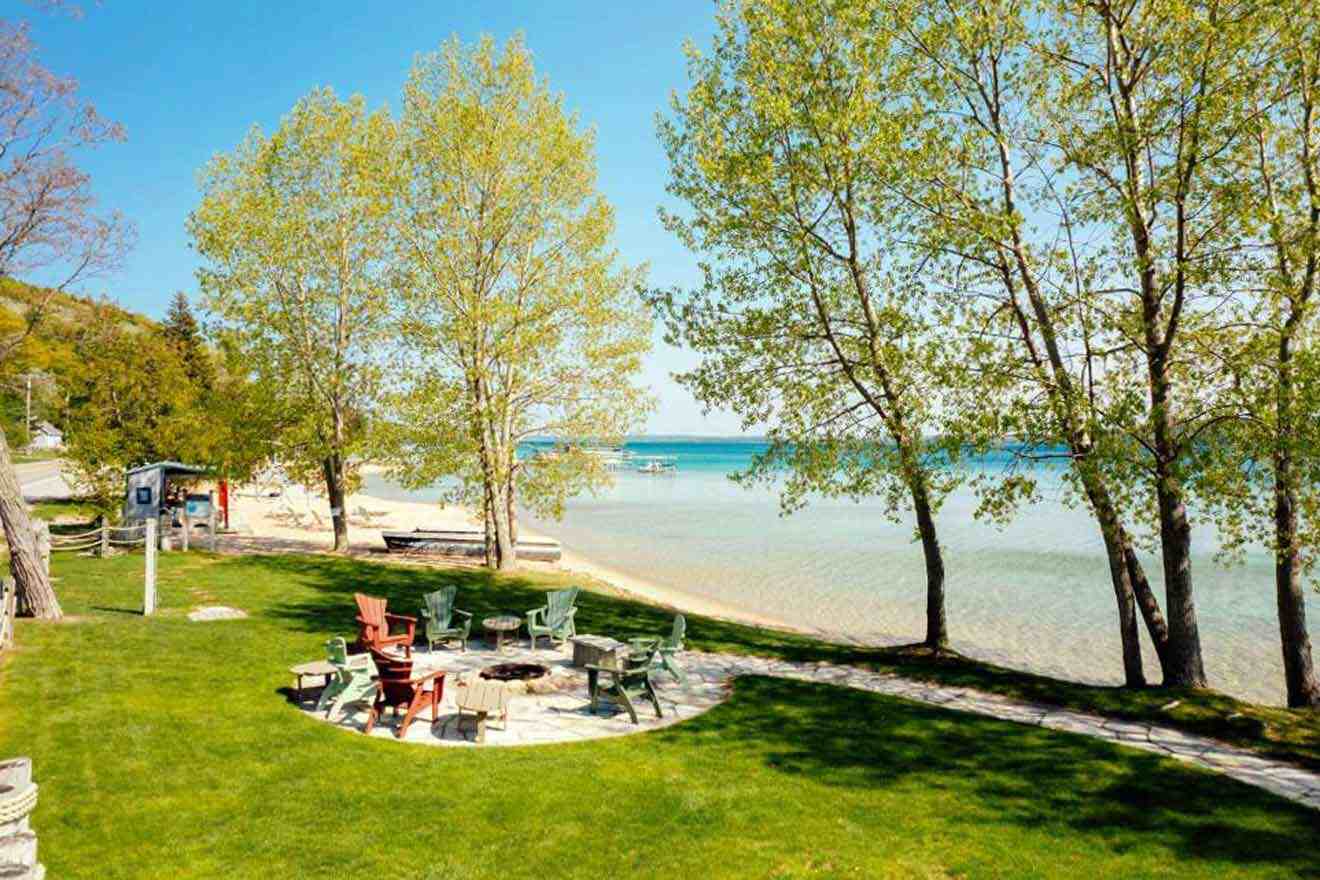 a fire pit in the middle of a grassy area next to a beach