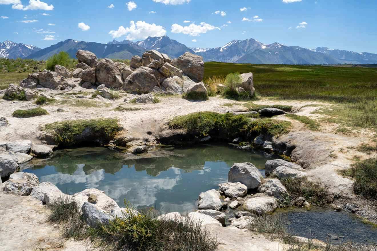 a hot spring surrounded by rocks and grass