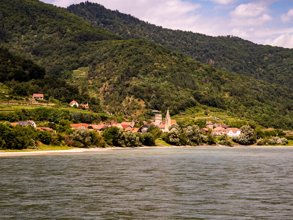 Houses and a church along a river bank