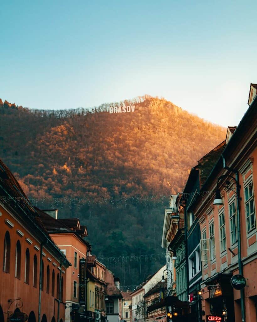 brasov sign on mountain overlooking village street 