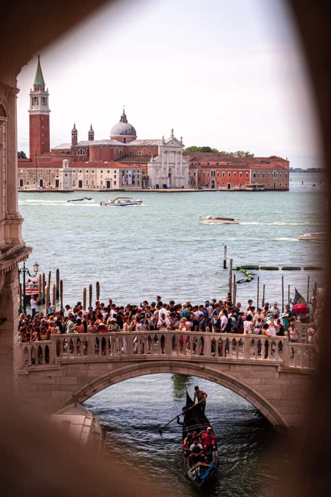 looking out small window of bridge of sighs for last look at venice canal and island