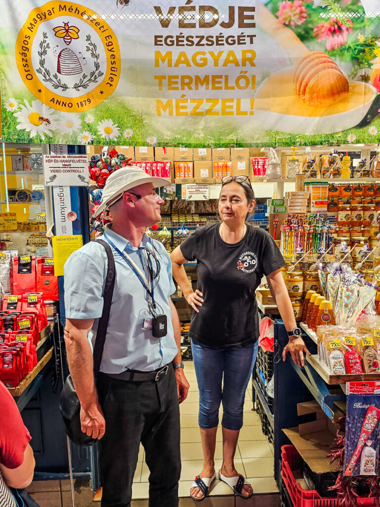 Man and lady standing in front of a store that sells honey