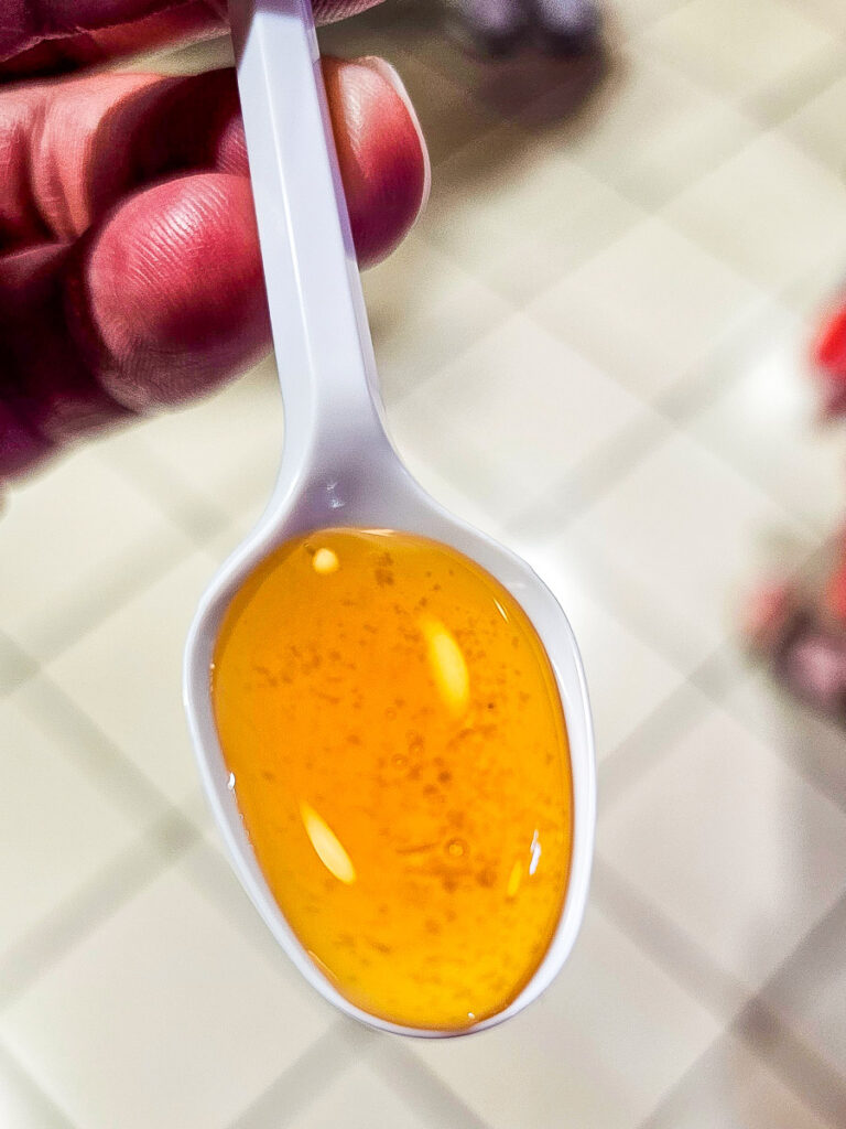 Honey on a white plastic spoon