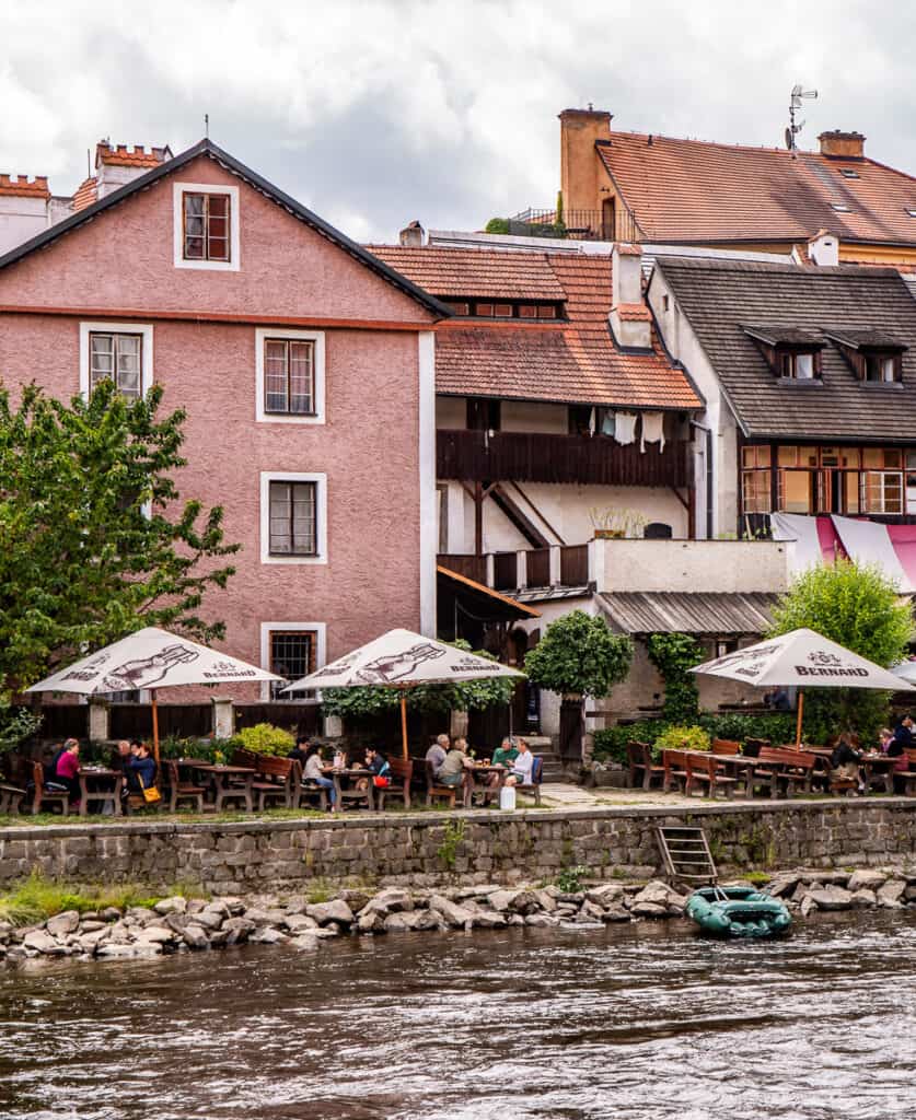 People sitting at a cafe by a river