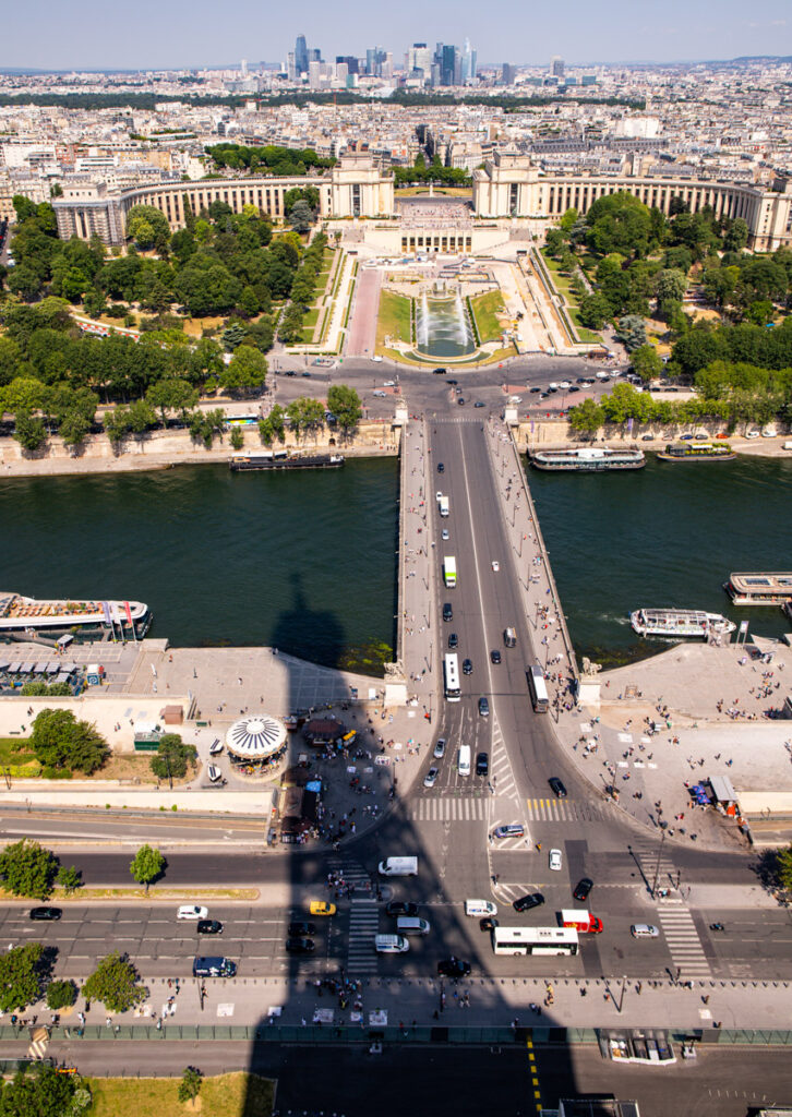 shadow of eiffel tower on ground in front of seine river