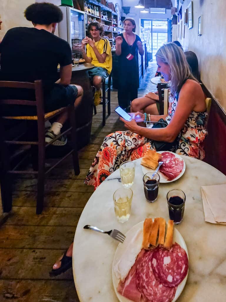 people listening to guide on food tour inside wine bar