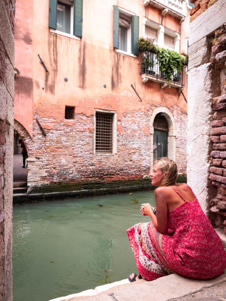 caz sitting on edge of pathway looking at canal