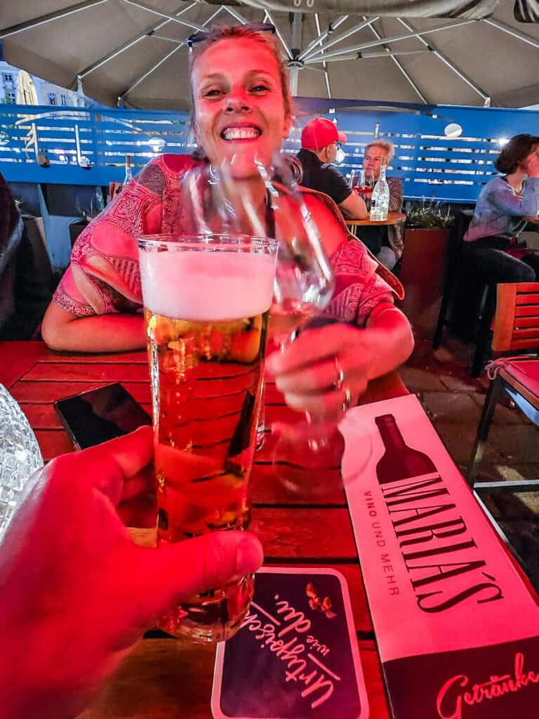 Woman drinking a glass of wine and man's hand holding a beer