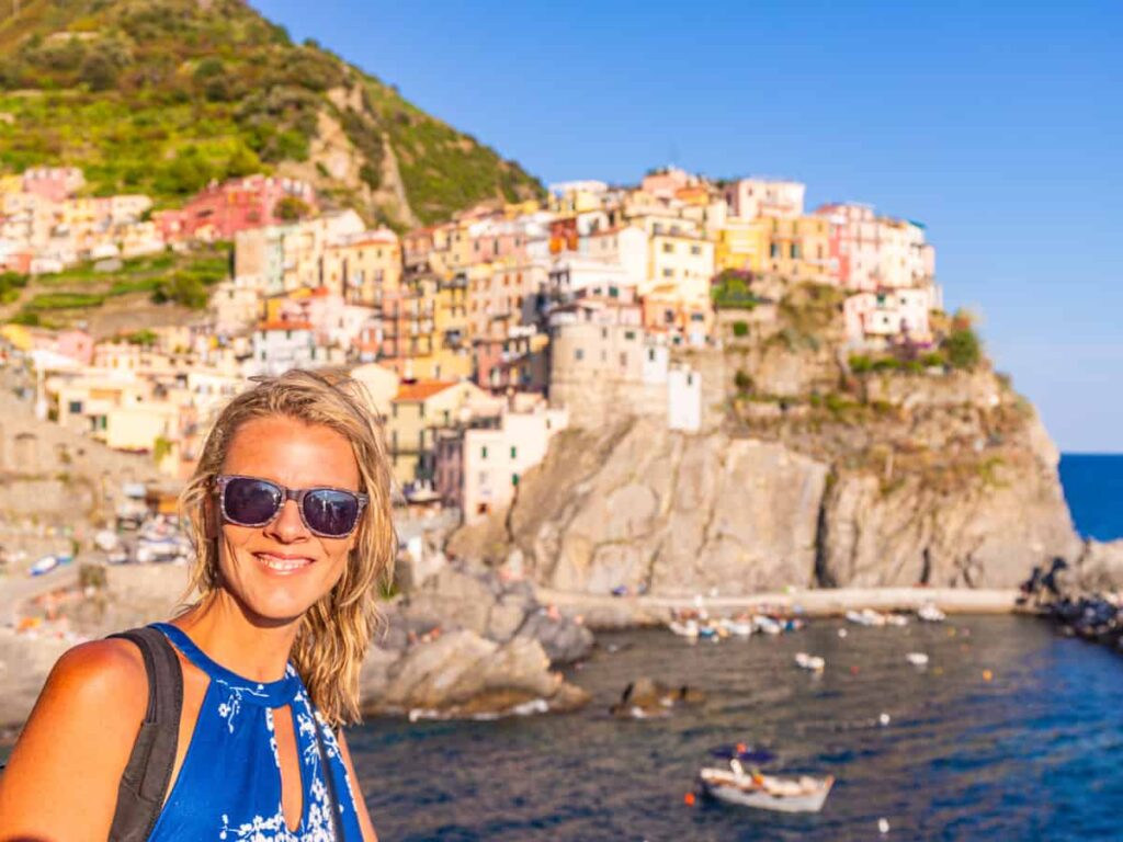 caz posing in front of colorful houses on clifftop