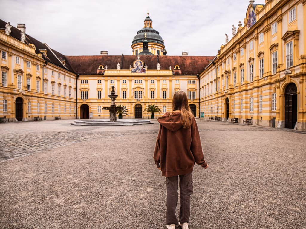 Young girl standing in the courtyard of an Abby