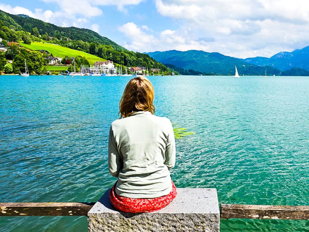 Lady sitting on rock overlooking a lake